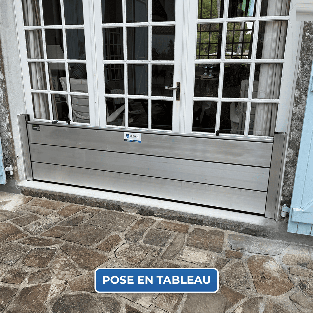 Batardeau CASTOR+ posé en tableau devant une porte-fenêtre, trois palplanches en aluminium entre deux glissières