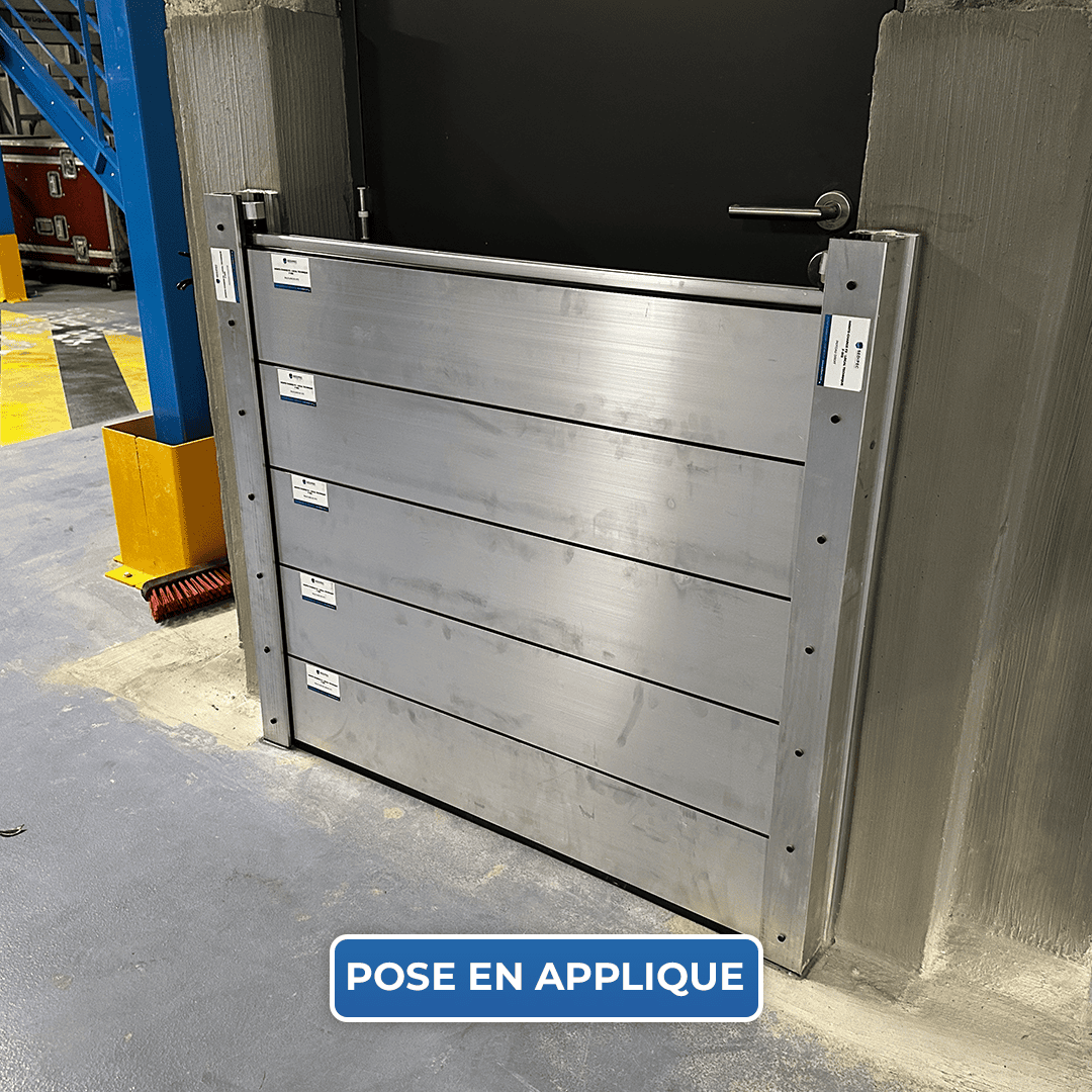 Batardeau CASTOR+ posé en applique devant la porte d’un local professionnel, palplanches entre deux glissières