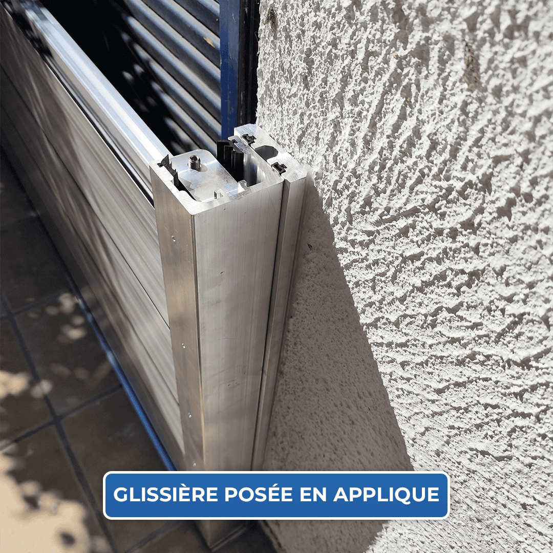 Gros plan sur une glissière du batardeau CASTOR+ posée en applique contre un mur crépi