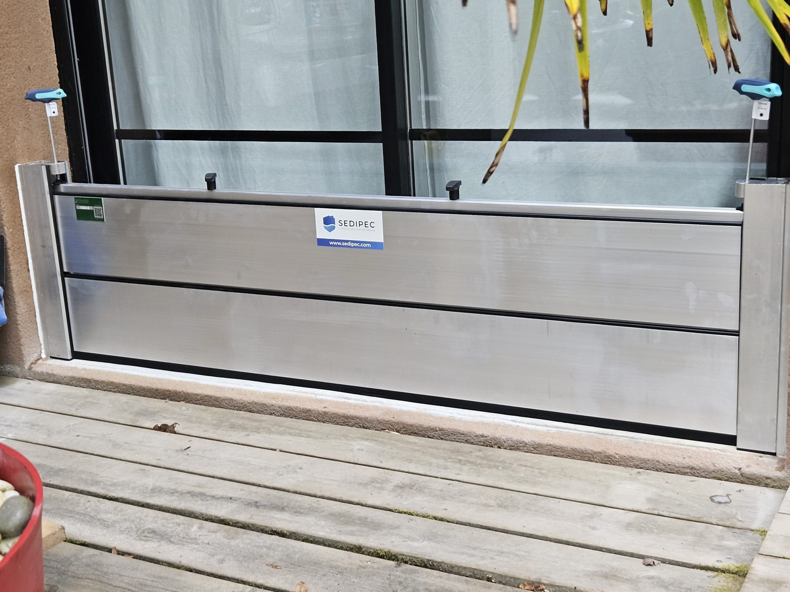 Palplanches empilées devant une baie vitrée