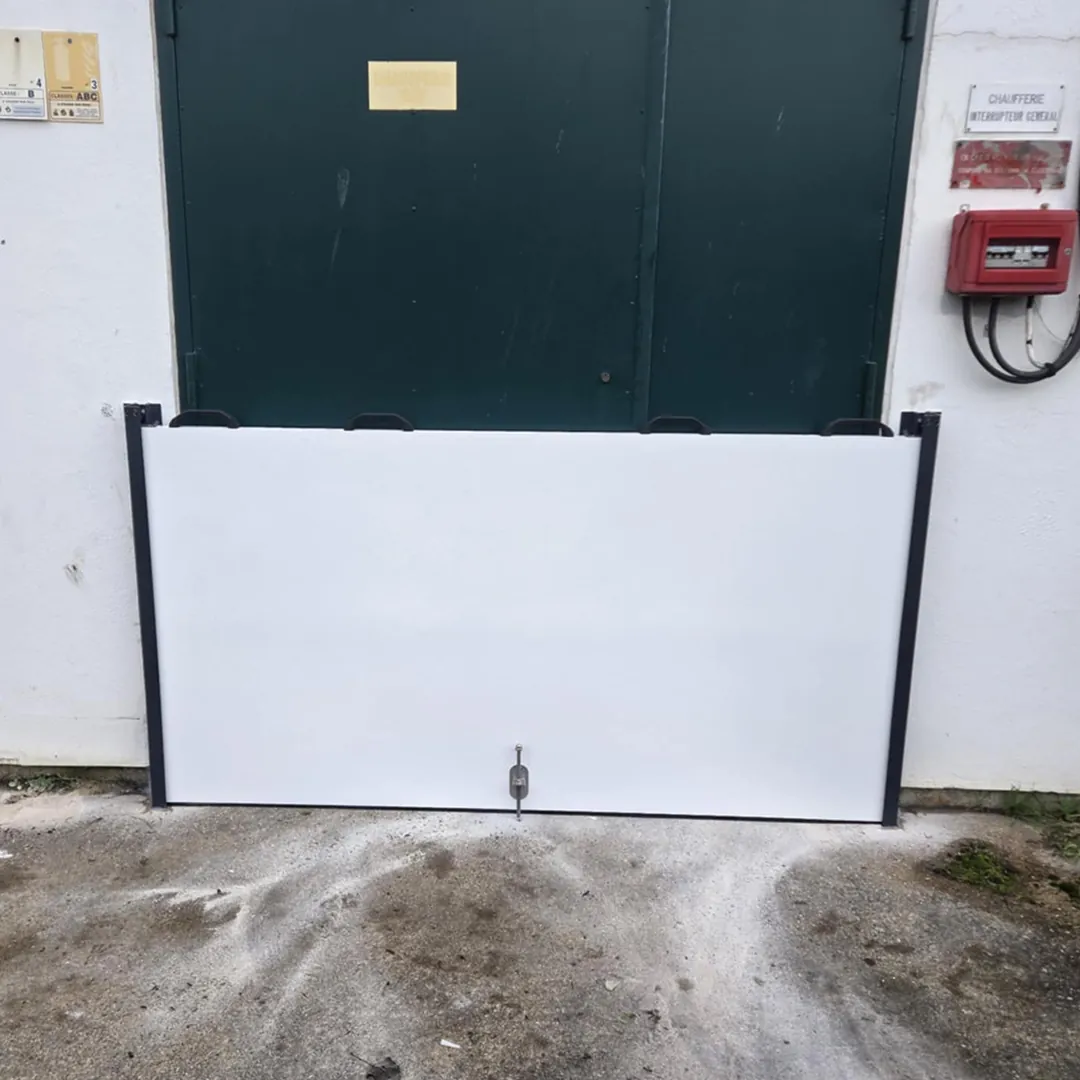 Panneau de batardeau monobloc posé devant une porte double extérieure de chaufferie