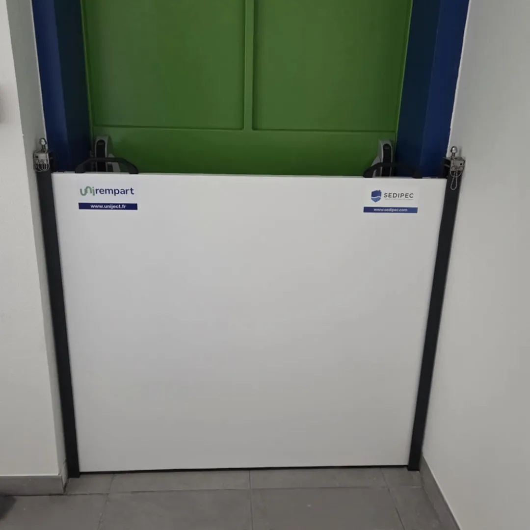 Panneau de batardeau UNI-REMPART logé dans ses deux montants latéraux au bas d'une porte intérieure
