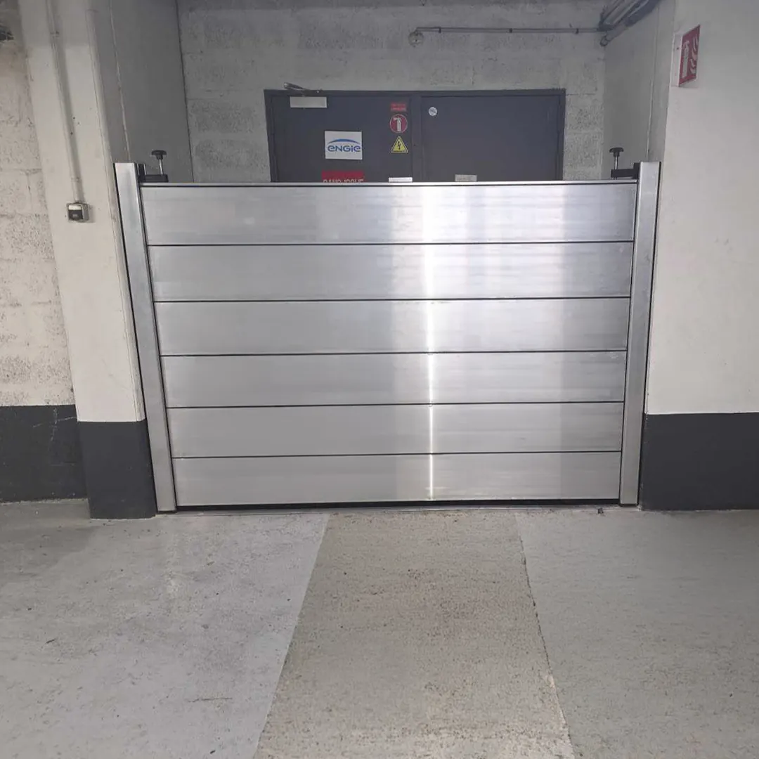 Batardeau aluminium à lames posé devant une porte double métallique
