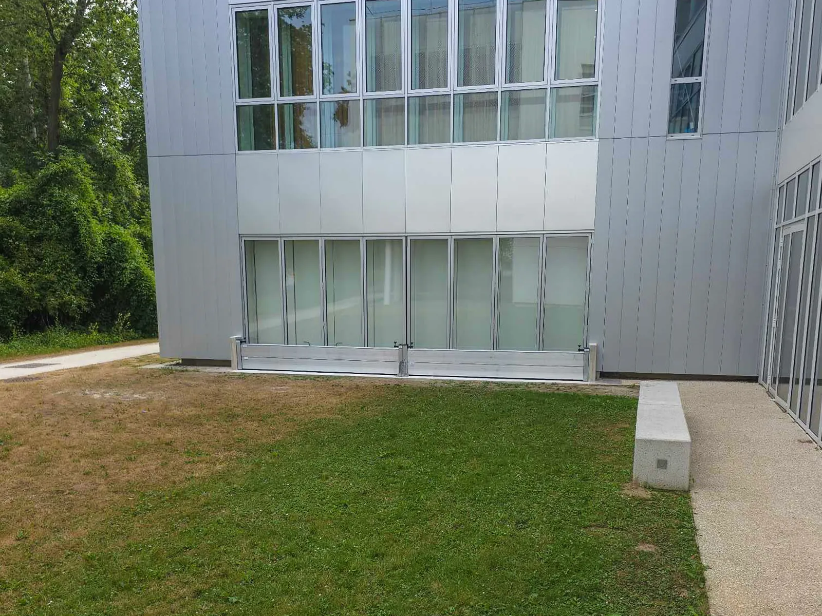 Batardeaux aluminium MODUL et CASTOR+ en deux travées devant une façade vitrée de bâtiment public en Essonne