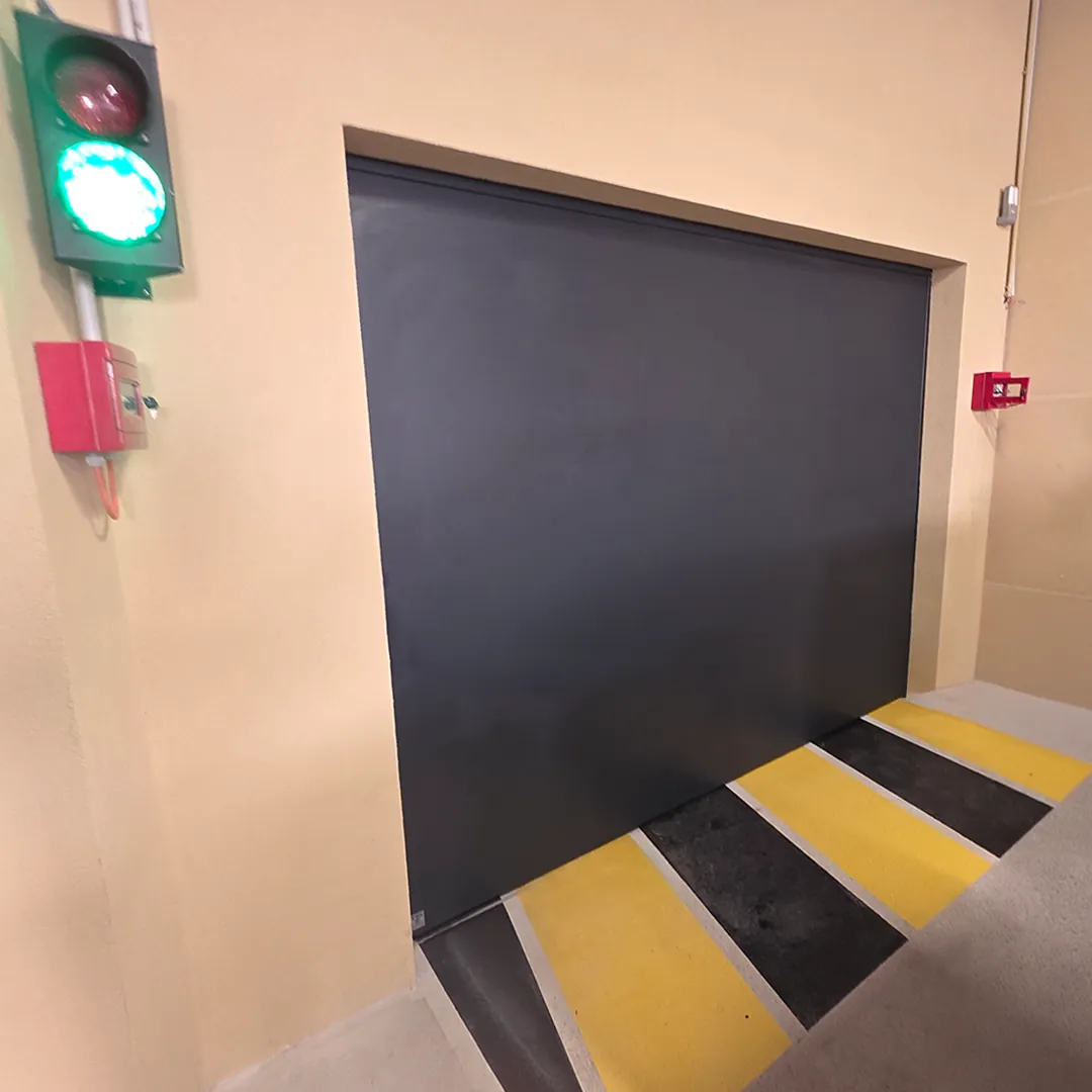 Porte de garage anti-inondation fermée à côté d'un feu de signalisation de parking
