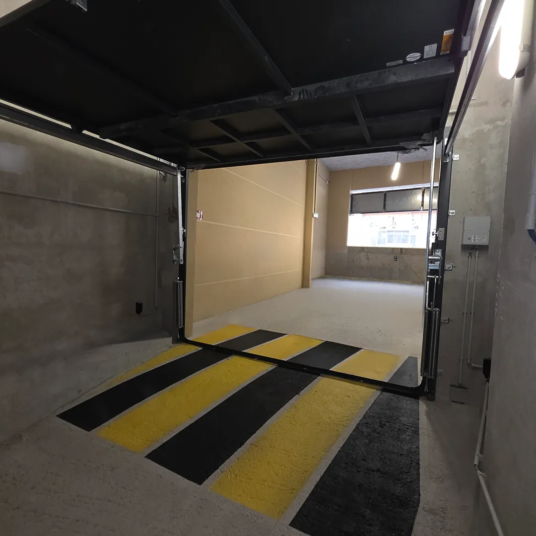 Porte de garage anti-inondation ouverte, vantail relevé au-dessus du passage