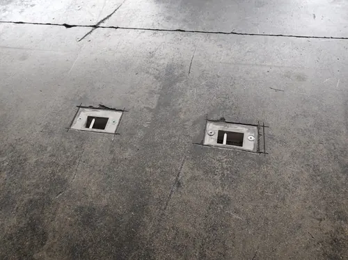 Deux boîtes de sol encastrées dans une dalle.